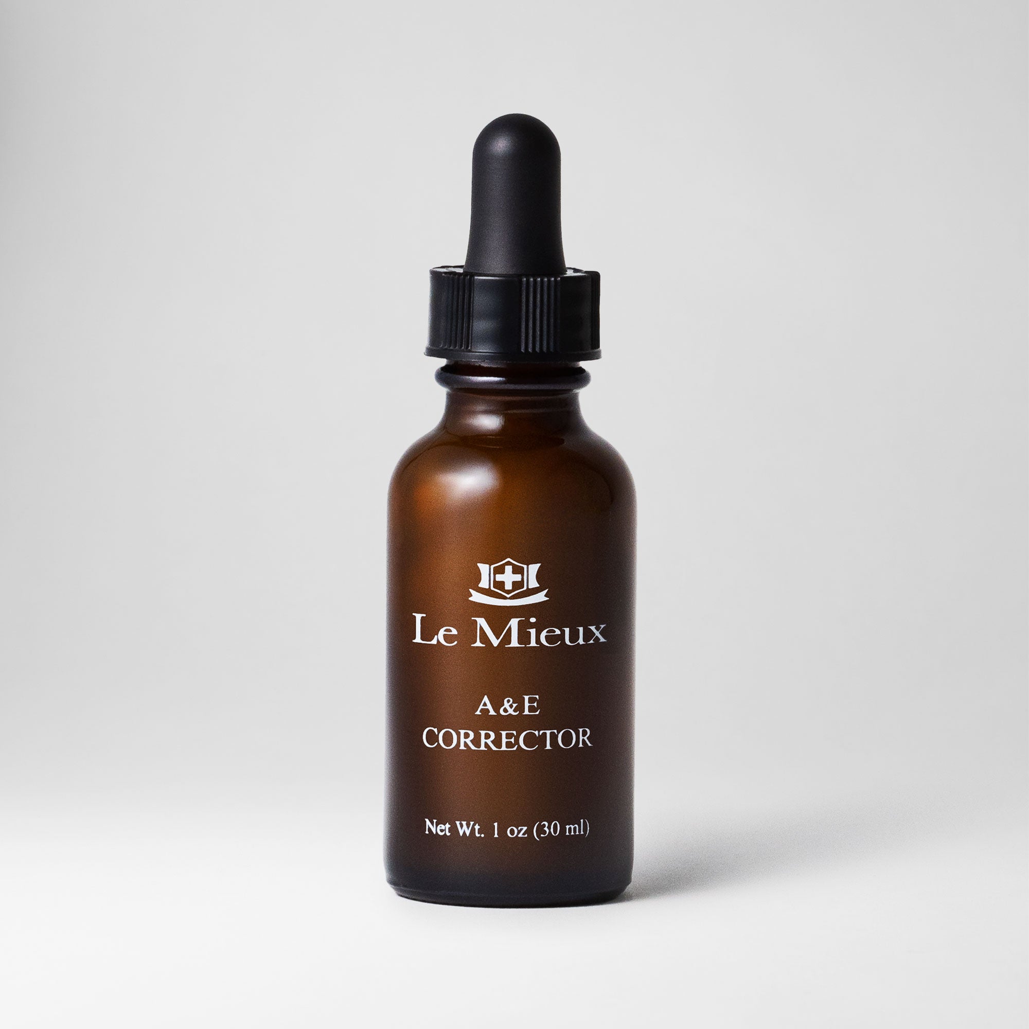 A&E Corrector 1 oz amber bottle with black dropper lid isolated on a light grey background