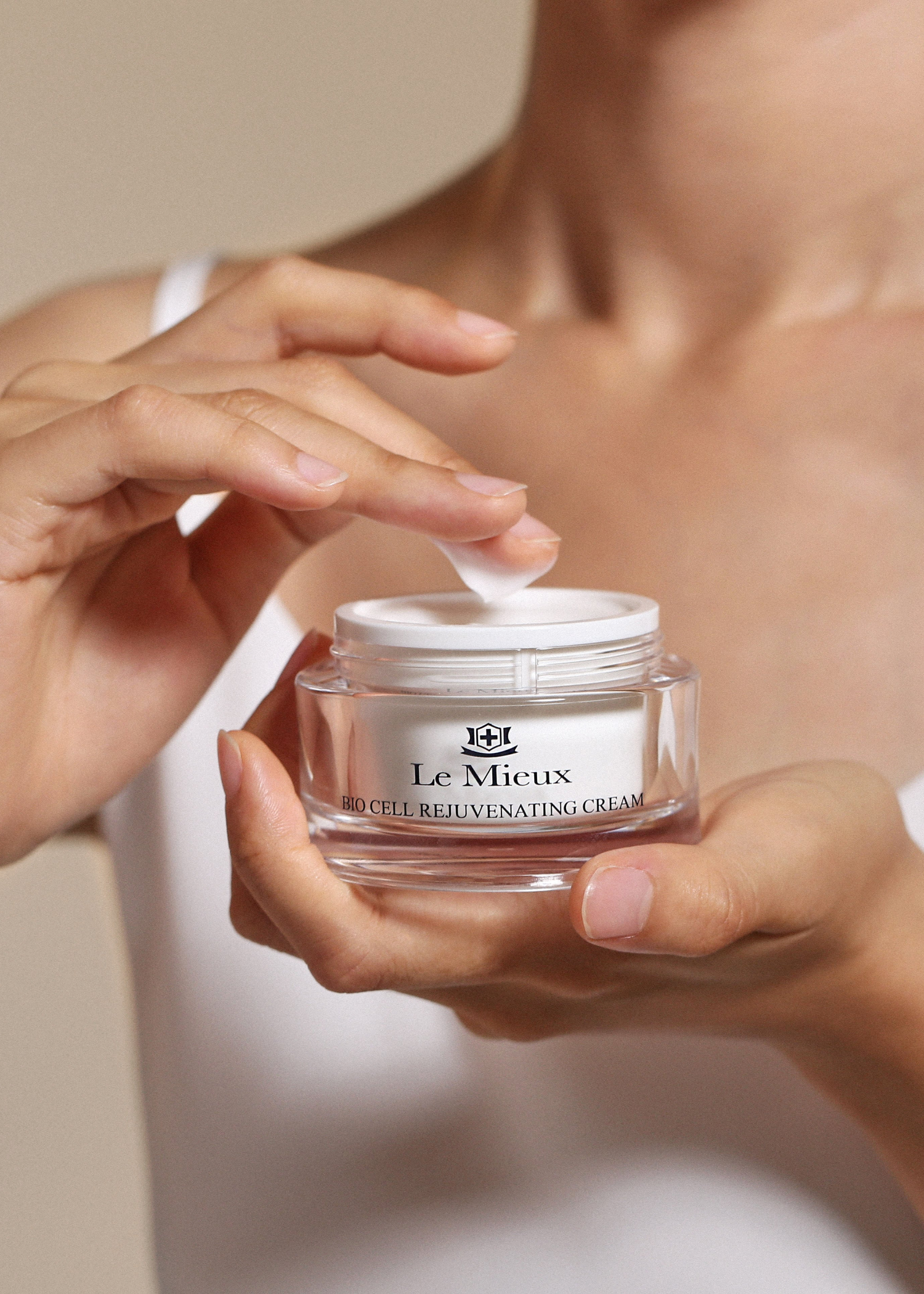 Person holding a jar of Le Mieux Bio Cell Rejuvenating Cream with a neutral background.