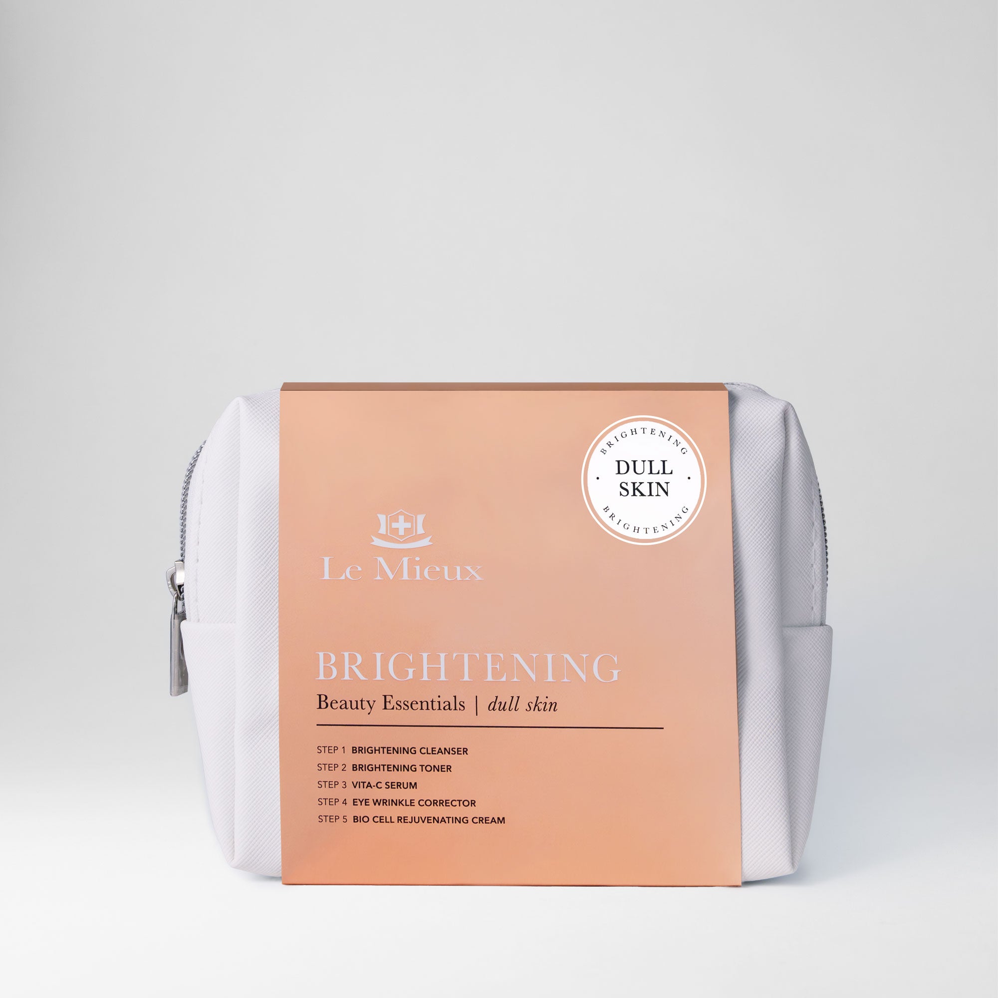 White bag with silver zipper and orange sleeve that says Brightening Beauty Essentials with Le Mieux logo in front of a light gray background.
