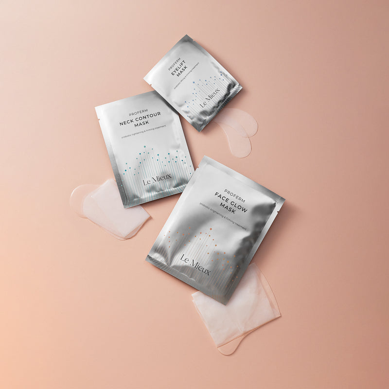 ProFerm Eyelift Mask, Neck Contour Mask, and Face Glow Masks laying above their respective damp mask products on a light pink background.